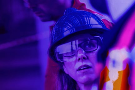 Female construction worker looking up towards male construction worker