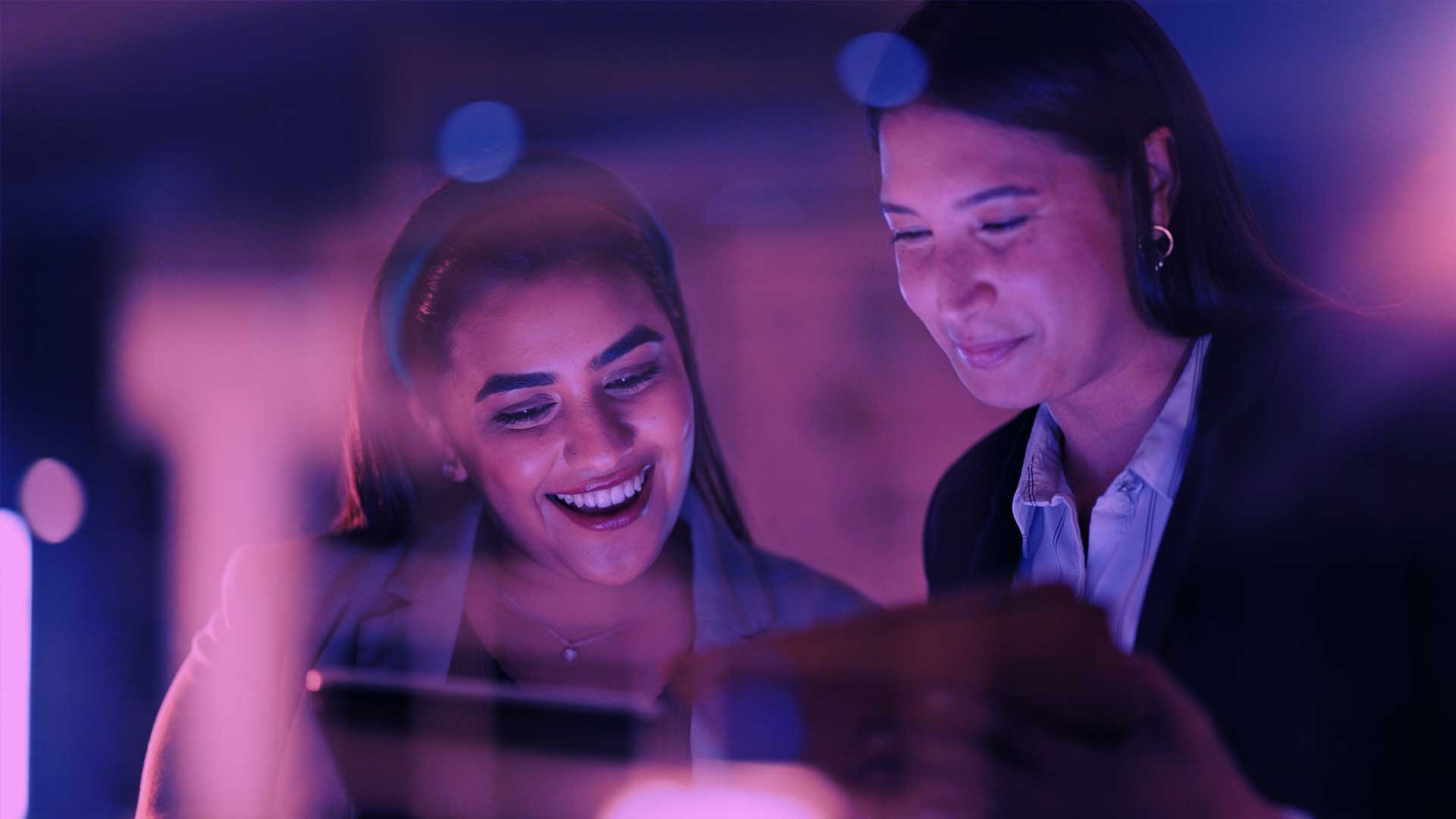 Two colleagues collaborating whilse on a laptop — human skills development at Hemsley Fraser